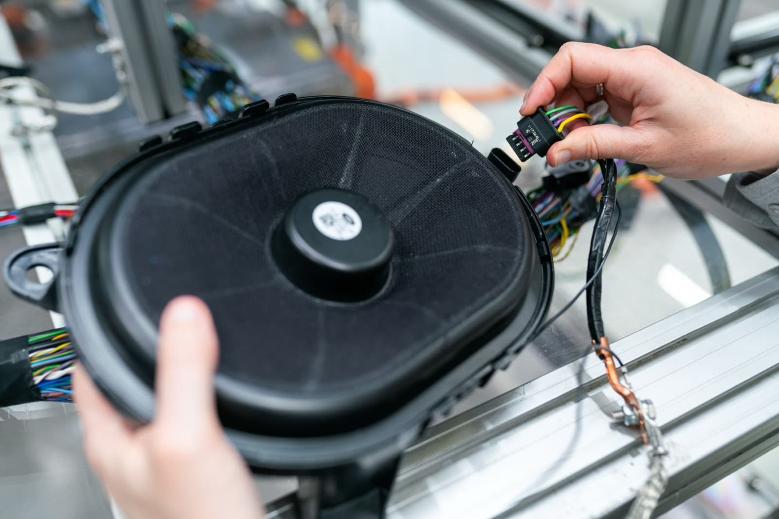 An engineer assembling a speaker on a production line